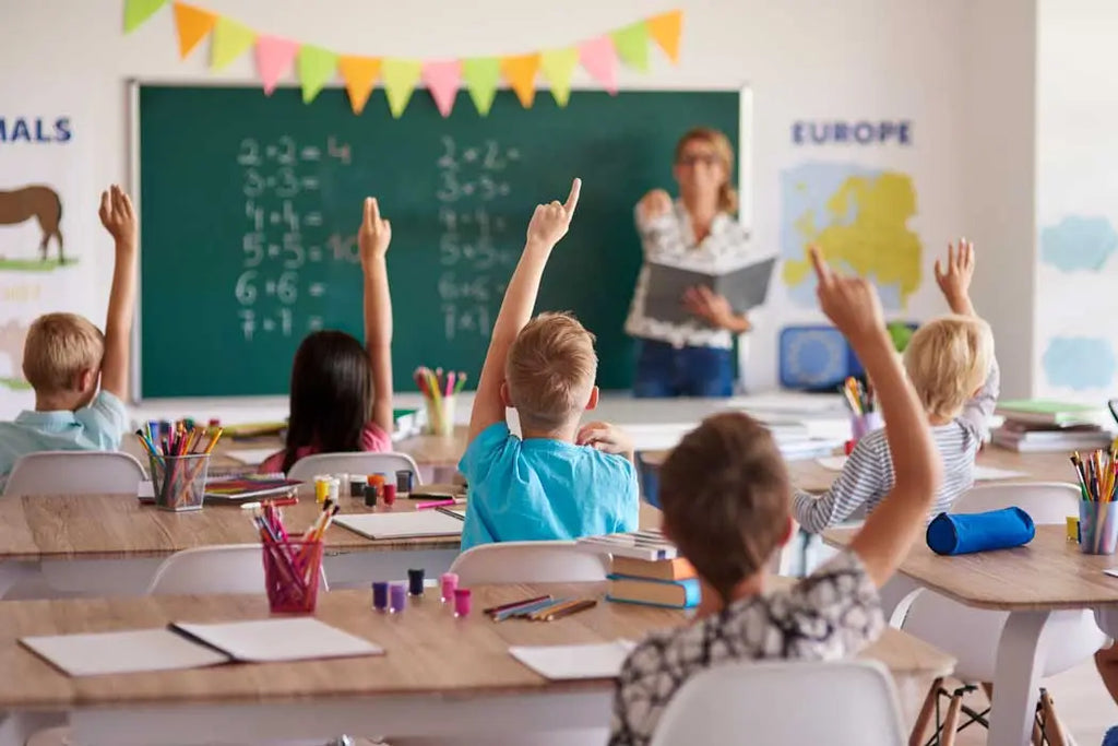 children raising hands in classroom representing kids with diabetes staying active and engaged at school