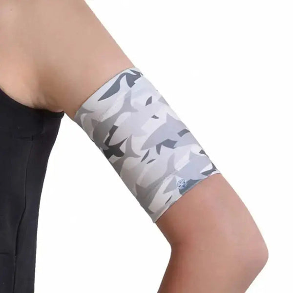 Blood glucose monitor armband in gray camo pattern on arm.