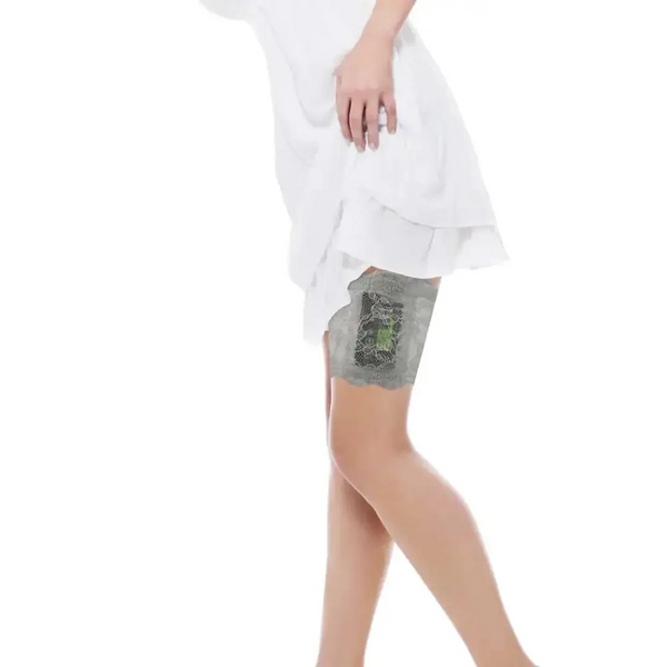 Woman wearing a grey lace garter holding an insulin pump on her thigh under a white dress, lace garter for insulin pump.