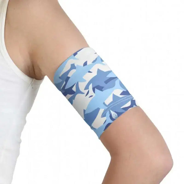 Glucose sensor armband for kids with blue sea-themed pattern, stretchy and secure fit.