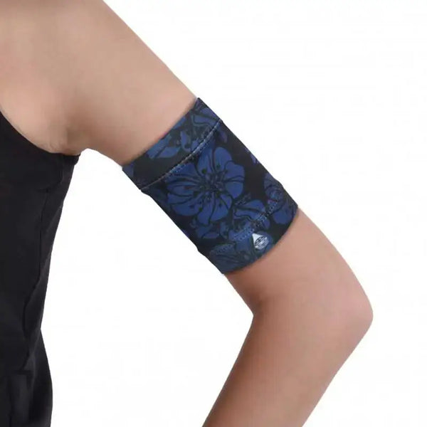 Stylish blood glucose sensor armband in dark printed colors, worn on upper arm.