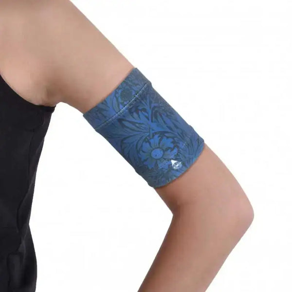 Stylish blood glucose sensor armband, Dia-Band Midnight, worn on upper arm with dark printed colors and breathable fabric.