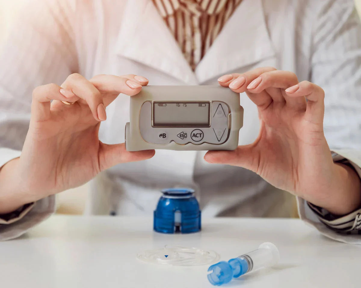 person holding blood glucose meter device with insulin pump components showing diabetes device maintenance and usage Image
