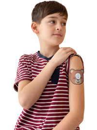 Barnplåster för Dexcom G7, form: björn, buret av en liten pojke